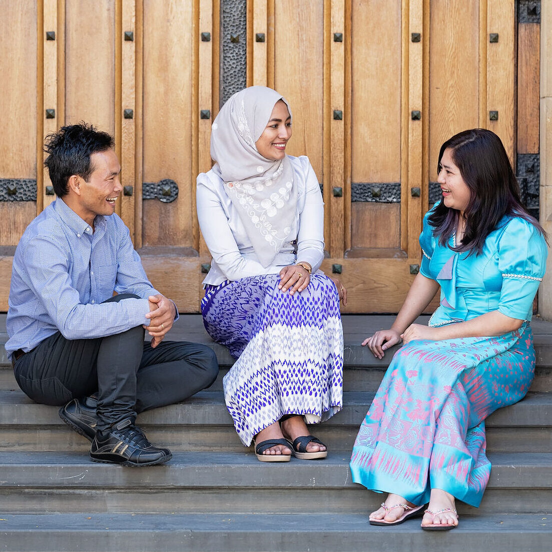 Three people sitting on steps and having a chat